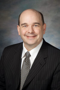 Smiling man in suit and tie.