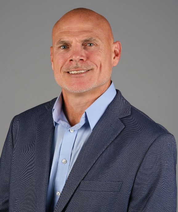Two men smiling and posing for a photo indoors.
