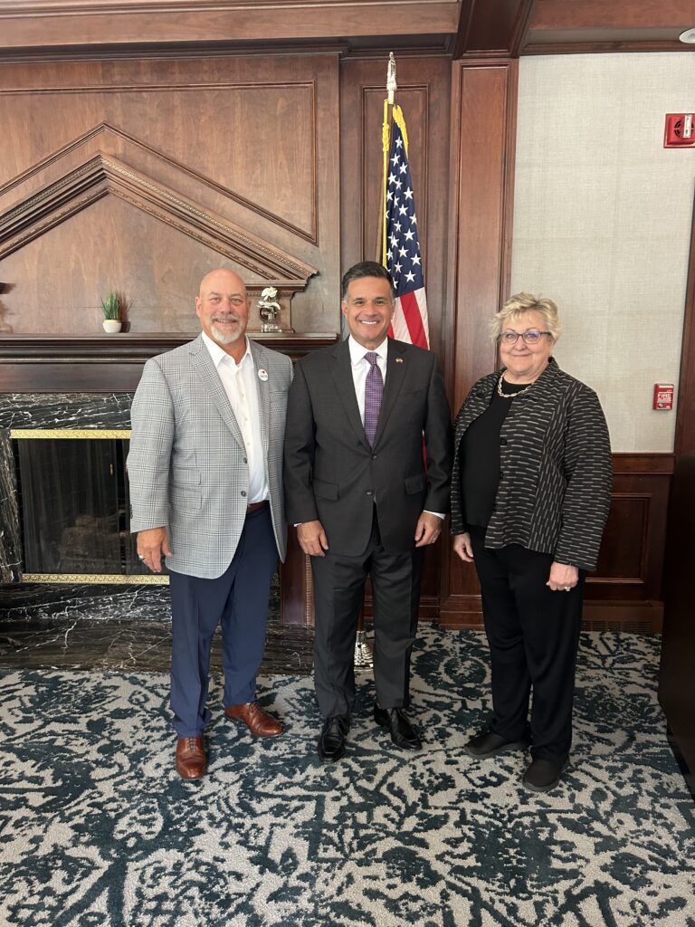 Two men smiling and posing for a photo indoors.
