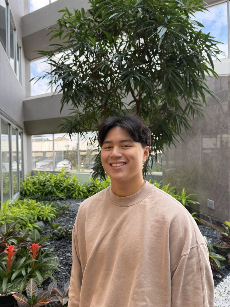 Smiling person in indoor garden setting.